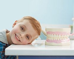Smiling child next tooth model