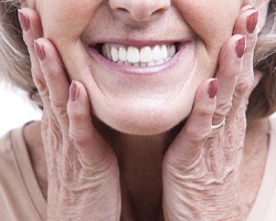 older woman smiling hands on face